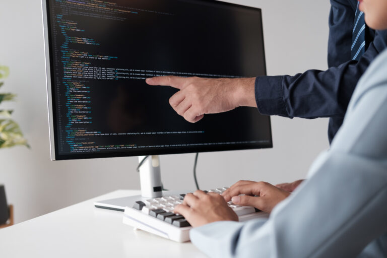 🚀 Tasks Every Startup Should Outsource Immediately team of programmer pointing to desktop computer with developing programming code, trying to solve the problem.